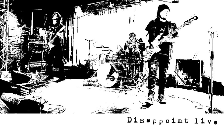 A black and white photo of Disappoint on stage